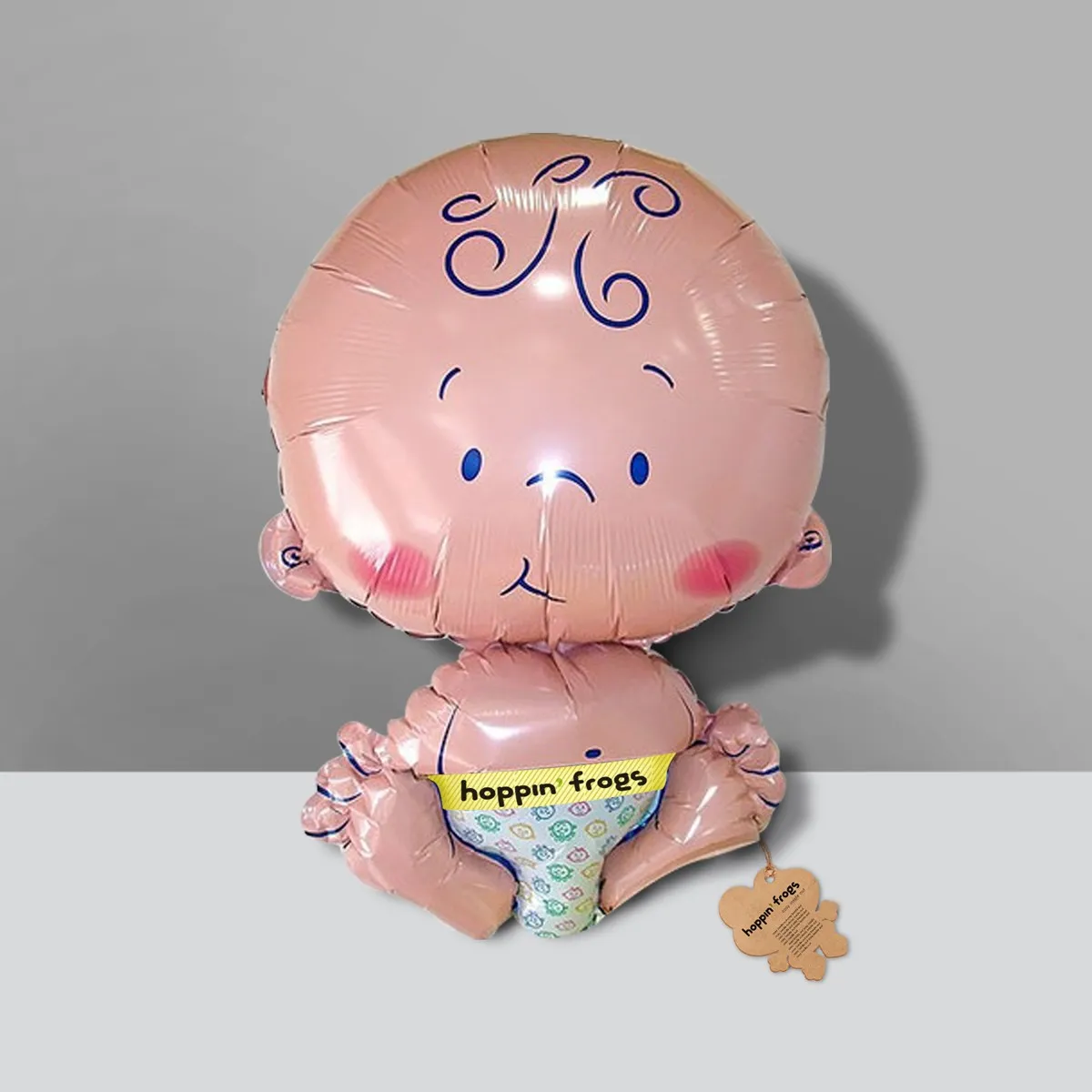 hoppin' frogs foil balloon baby figure — pink metallic seated baby shape with hoppin' frogs branded diaper in frog-print fabric; frog-shaped hang tag; gifting concept