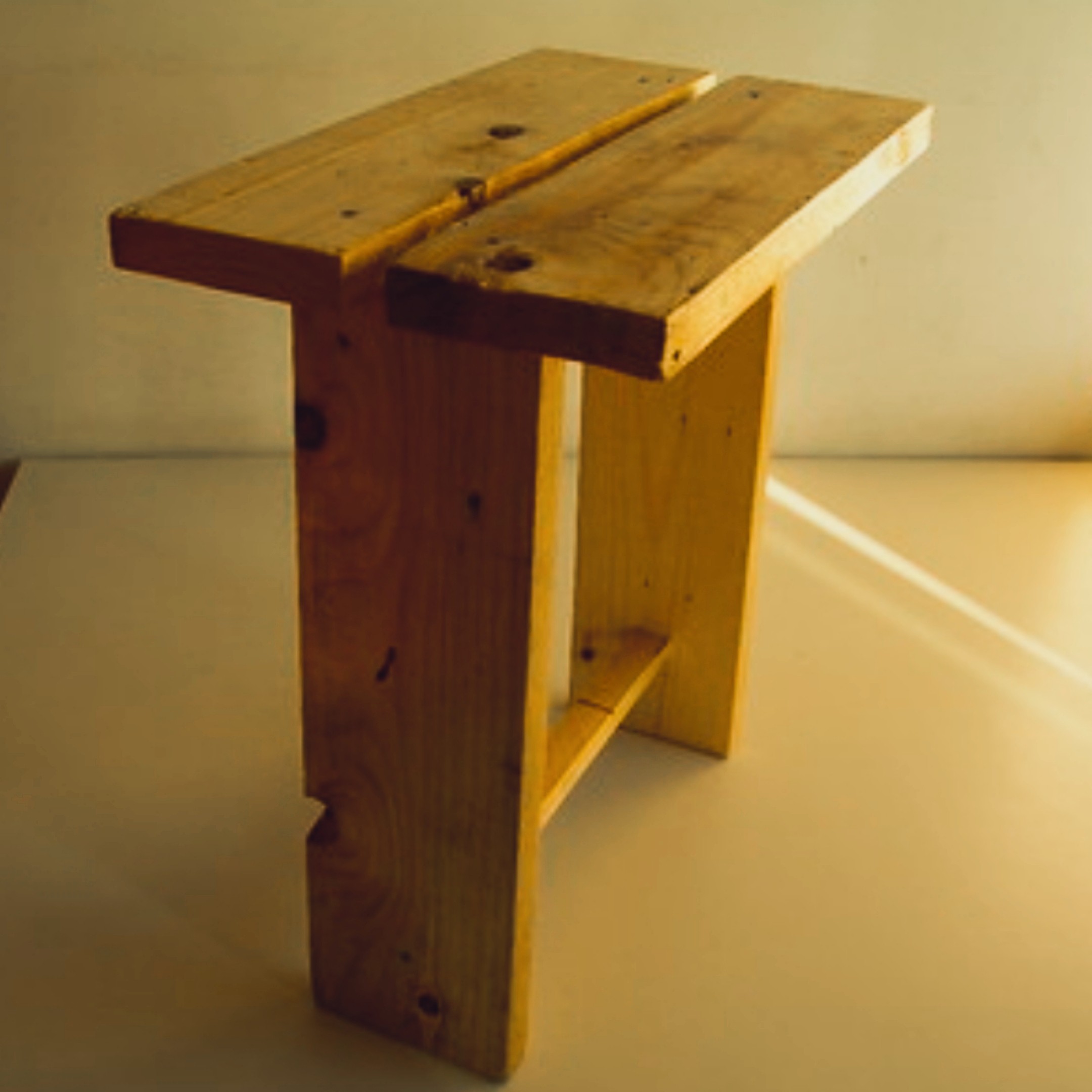 Small pinewood side table in raw unfinished state — clean joinery, warm golden light