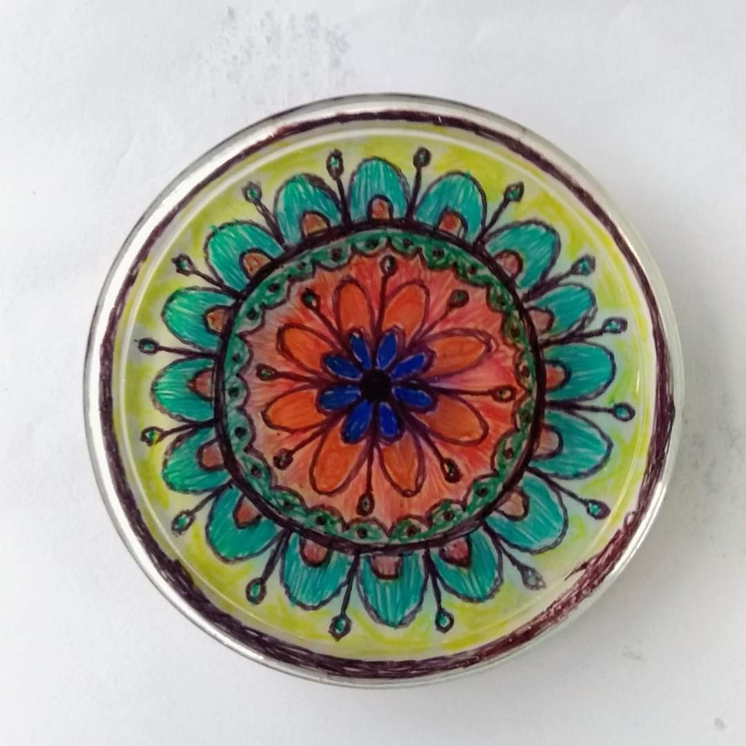 Round resin mandala — teal petals, orange-red centre, small blue flower at core, lime-yellow background, set in tin lid