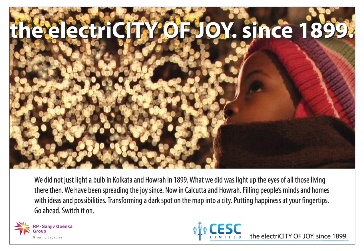 Power utility corporate print ad — 'the electriCITY OF JOY. since 1899.' — child in winter looking at city lights, CESC branding